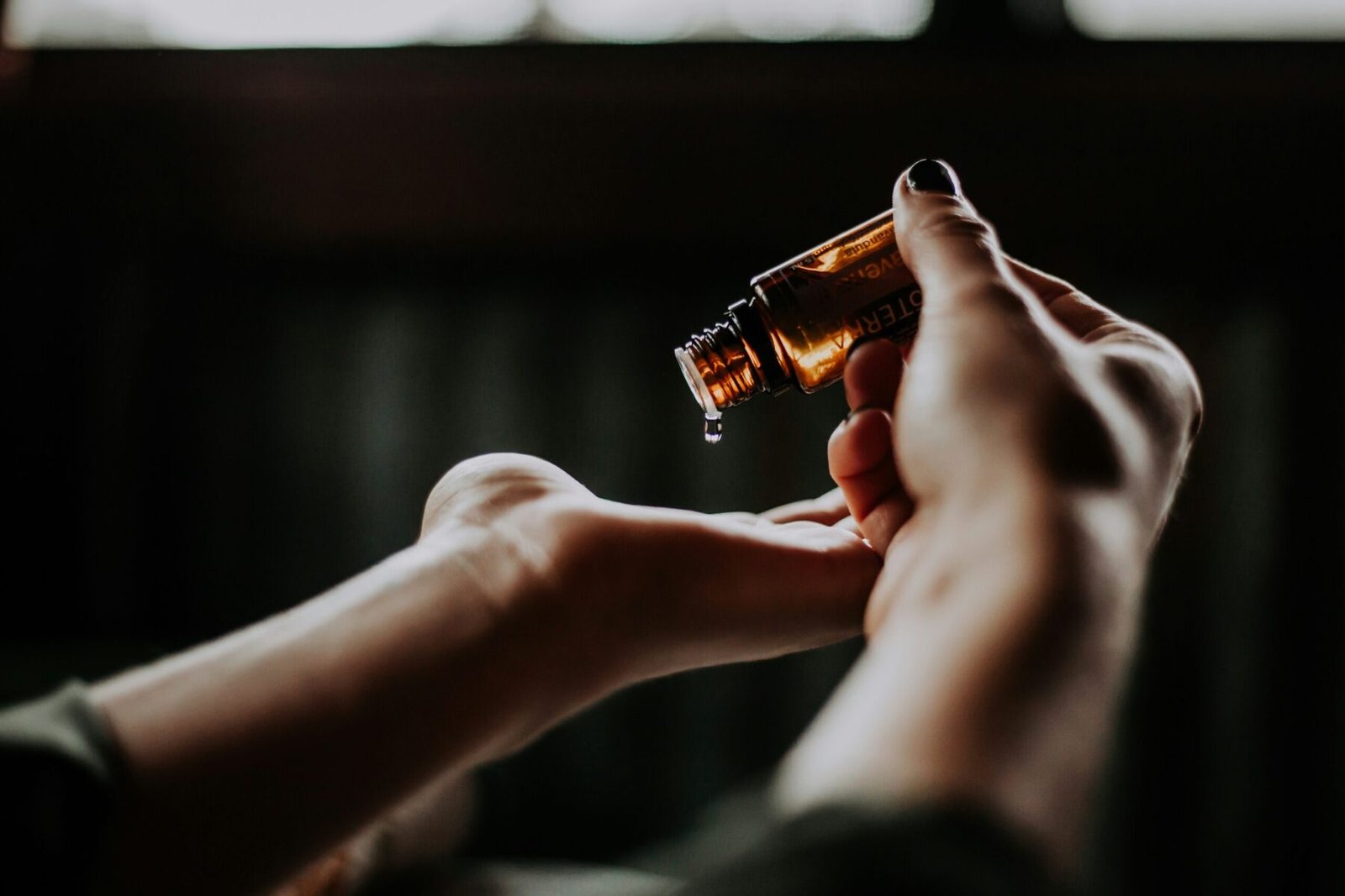 person holding amber glass bottle of Lavender Oil